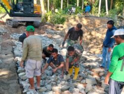 Anggota Koramil 1315-01/Telaga Dampingi Pemasangan Batu Fondasi Armco Demi Percepatan Pembangunan Desa Ulapato B