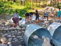 Anggota Koramil 1315-01/Telaga Kawal Pekerjaan Pemasangan Batu Jembatan Armco Di Desa Ulapato B Telaga Biru