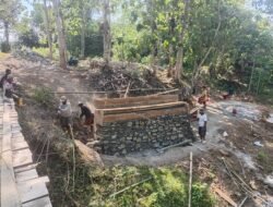 Pembangunan Jembatan Garuda Berlanjut, Babinsa Boliyohuto Dampingi Pemasangan Batu Koporan Pondasi